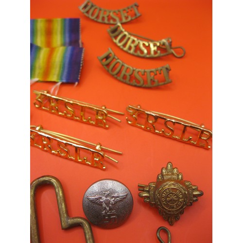 362 - A small collection of military items including Dorset Regt and other shoulder titles in brass, a Mil... 