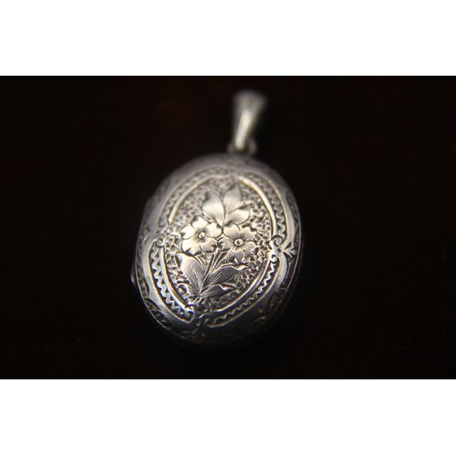 33 - A sterling Silver locket with floral decoration and blank cartouche