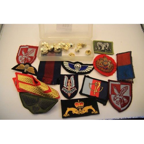 153 - A small tub containing various military patches and badges including airborne wings, plus a selectio... 