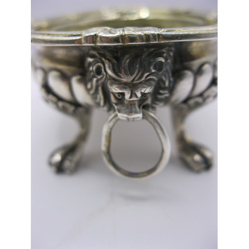 307 - An antique sterling silver mustard bowl with lion's head handles and claw feet, fluted decoration to... 