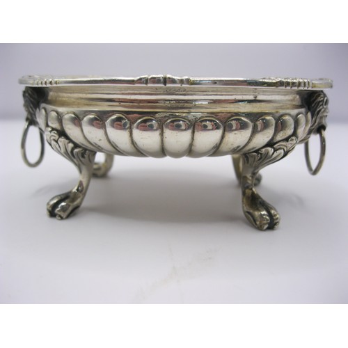 307 - An antique sterling silver mustard bowl with lion's head handles and claw feet, fluted decoration to... 