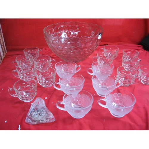 117 - A large punchbowl with 12 matching glasses and hooks to hang from edge of bowl, plus a further 6 gla... 