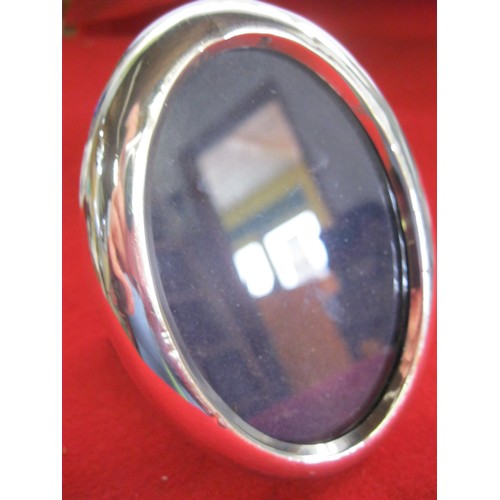 152 - A small oval photo frame in sterling silver, UK import hallmarks