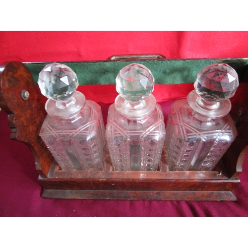 62 - A 19th three decanter early lockable tantalus by  Betjemann
stamped London with crest
The three deca... 