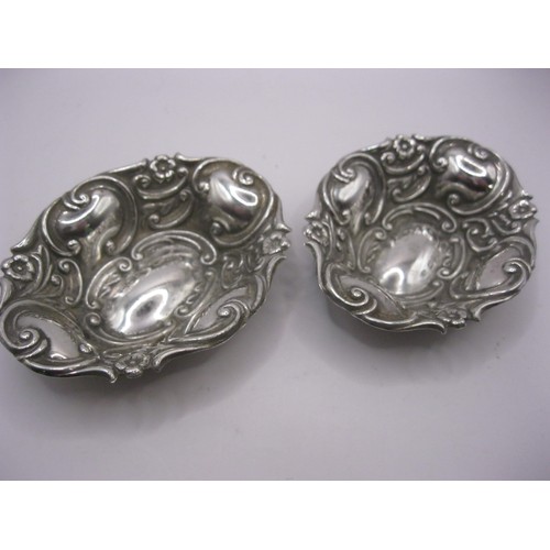 105 - A matching pair of small sterling silver trinket dishes with repousse decoration, hallmarked for Bir... 