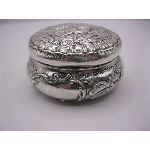 152 - An ornate embossed continental silver circular snuff box with lid, London import marks for 1894, app... 