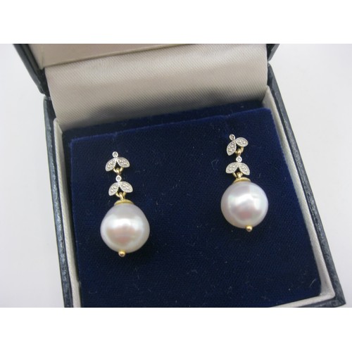 219 - A pair of 9 carat gold drop earrings set with large pearls on ornate diamond set drops