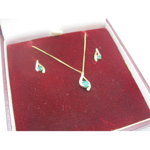 359 - A 9 carat gold pendant set with emerald and small diamonds on fine chain with matching earrings