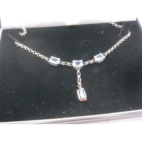 365 - A 9 carat white gold chain set with four blue topaz emerald cut stones, approx weight 15g