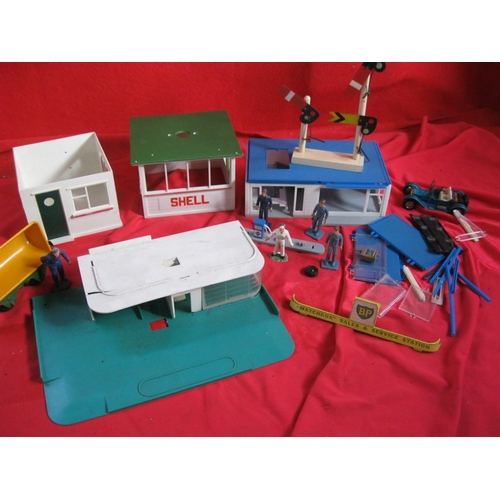 296 - An assortment of plastic garage and other buildings in various scales, assorted figures and a metal ... 