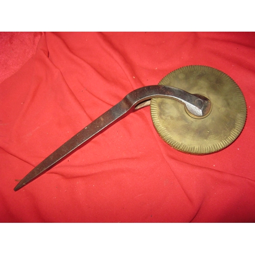 351 - A heavy duty brass embossing wheel mounted on a metal arm with spike to end