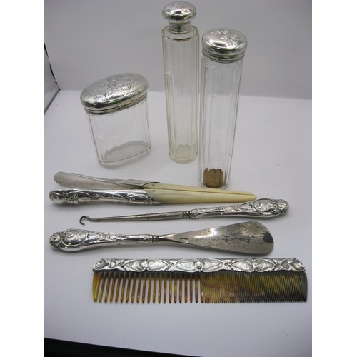 117 - A 7 piece silver dressing table set by William Comyns of Angel Head Design, 3 jars, comb, shoe horn,... 