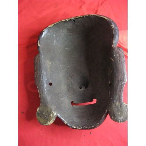 7 - An antique carved wooden Oriental face with remnants of painted finish