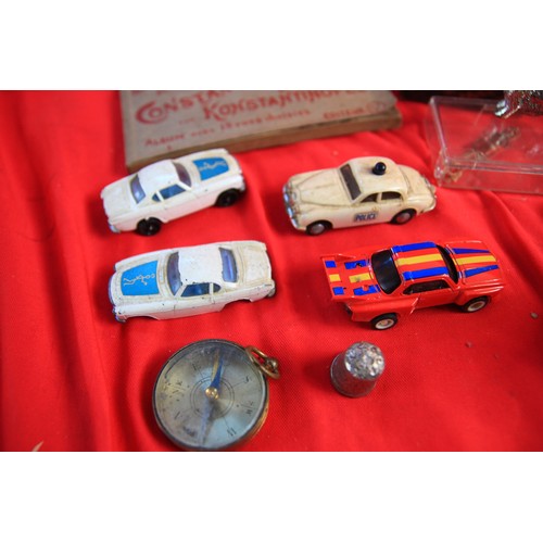 247 - A tin of interesting items including a Corgi Rockets 'The Saint' Volvo, a Mimic Jaguar Police slot c... 