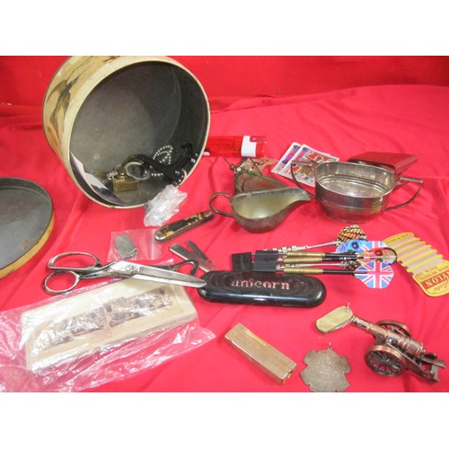 34 - A tin of interesting Items, including a lighter, buttons, darts, penknives, a selection of Boer War ... 