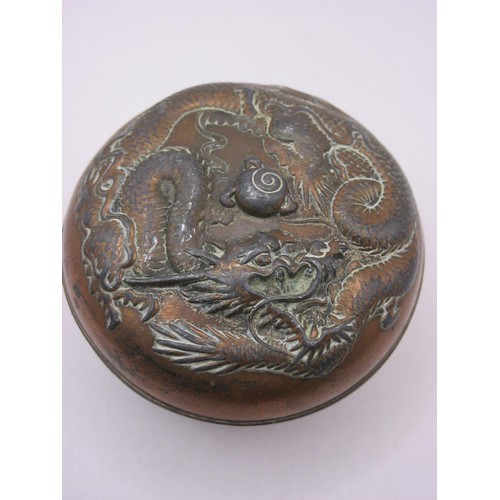 191 - A small but heavy Chinese copper pot, covered in copper, with ornate dragon chasing pearl design to ... 