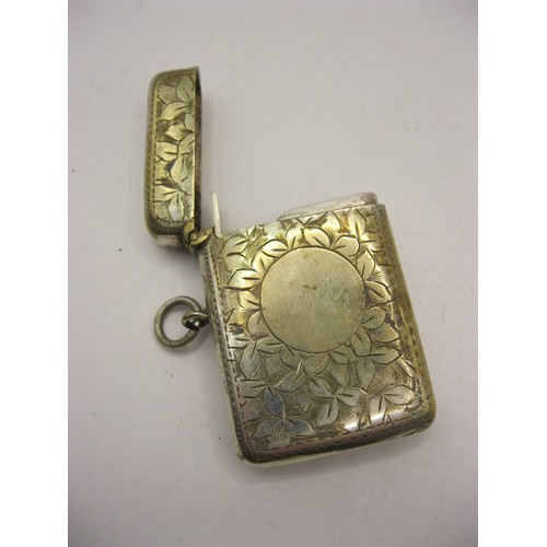 199 - A larger vesta case with fob ring and integral striker, engraved floral decor to case with blank car... 