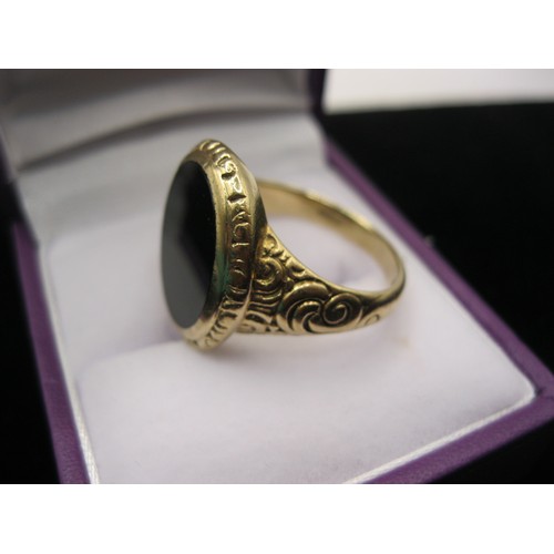 295 - A substantial gentleman's signet ring in 9 carat gold, black stone and nicely engraved decoration, s... 