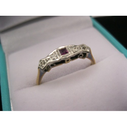 296 - An 18 carat gold ring with platinum mount and set with a ruby and two small diamonds in an art deco ... 