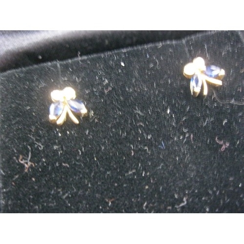 298 - A pair of 9 carat gold earrings in the form of small bows, each set with 2 sapphires and 2 diamonds