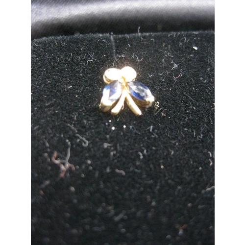 298 - A pair of 9 carat gold earrings in the form of small bows, each set with 2 sapphires and 2 diamonds