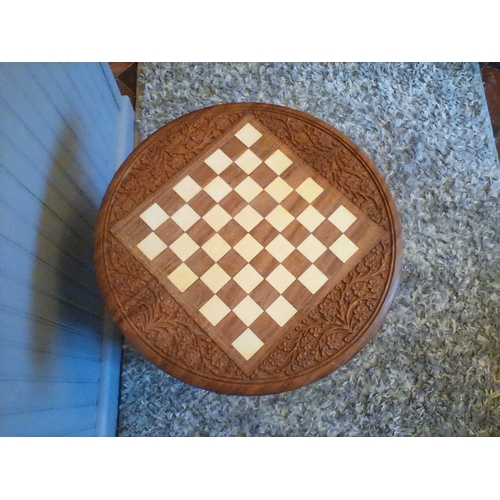 307 - A hand carved hard wood chess table with peacock design fretwork on 3 hinged folding legs, 18