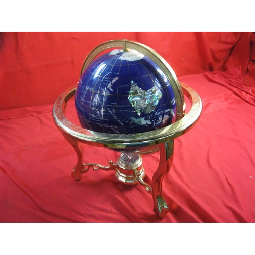 159 - A modern and decorative tabletop globe with a simulated specimen stone inlay and a brass coloured me... 