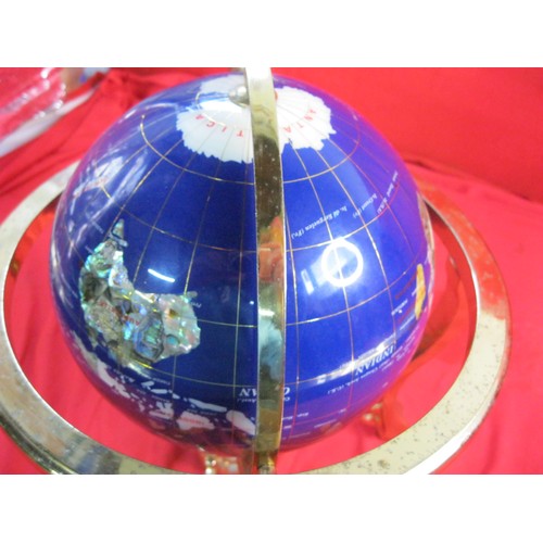 159 - A modern and decorative tabletop globe with a simulated specimen stone inlay and a brass coloured me... 