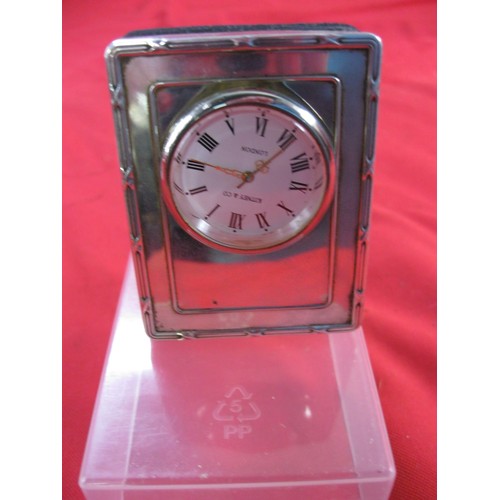 193 - A small silver clock stand, hallmarked for London 1996, with a removable clock, the dial marked for ... 