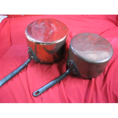 99 - Two antique copper saucepans stamped HARRODS LD with riveted iron handles, the larger of 23.cm diame... 