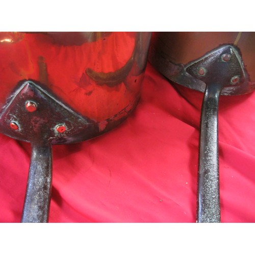 99 - Two antique copper saucepans stamped HARRODS LD with riveted iron handles, the larger of 23.cm diame... 