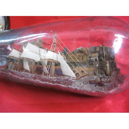 165 - A ship in bottle (length of ship 12cm, the bottle is 31cm overall and modelled with a quayside diora... 