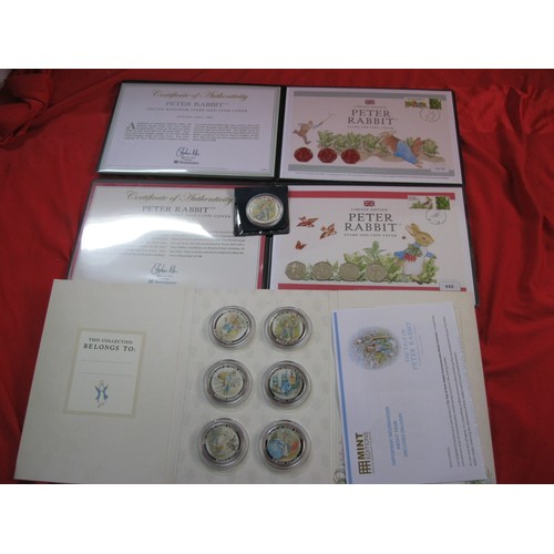 24 - An assortment of Beatrix Potter commemoratives, including a pair of first day cover and coin packs, ... 