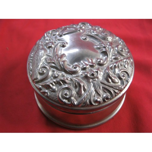 112 - A sterling silver velvet lined trinket box with repousse decoration to lid featuring birds etc, by B... 
