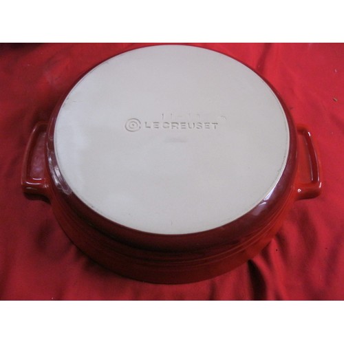 127 - An orange Le Creuset lidded crock pot and a smaller red Le Creuset lidded casserole dish, both in go... 