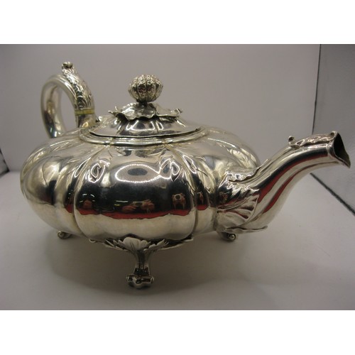 6 - A substantial George IV teapot of squat watermelon form with foliate decoration and claw feet, hallm... 