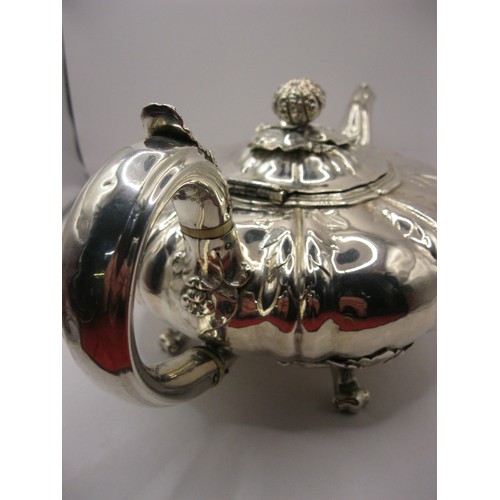 6 - A substantial George IV teapot of squat watermelon form with foliate decoration and claw feet, hallm... 