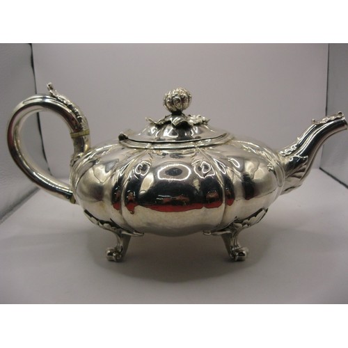 6 - A substantial George IV teapot of squat watermelon form with foliate decoration and claw feet, hallm... 