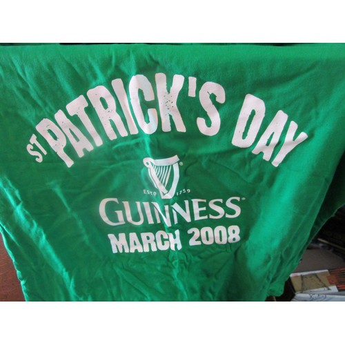284 - A tray of pub promotional items including St Patrick's Day items to include T shirts, Hats and a ban... 