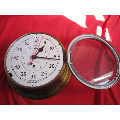 167 - A large brass WW2-era Royal Navy ship's bulkhead clock, marked with the 'crow's foot' of the Admiral... 