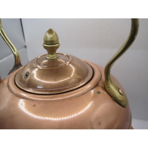 39 - A hand hammered copper kettle with rivetted handle with a matching spirit burner in decorated heatin... 