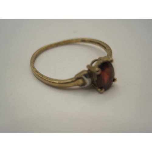 39 - A delicate 9 carat gold ring set with a red stone, likely a garnet, ring size O/P, approx weight 0.9... 