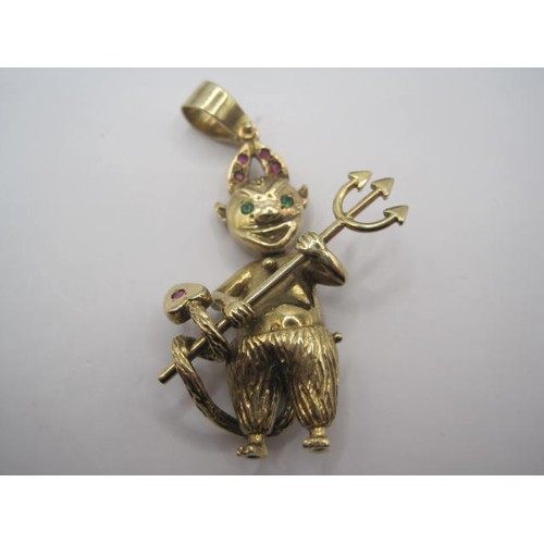 43 - An articulated 9 carat gold pendant of a devil, the horns set with amethysts, the eyes in green ston... 