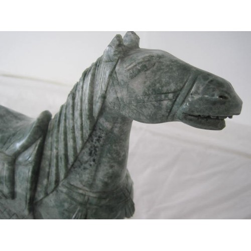 127 - A carved green stone model of a horse in the Chinese archaistic style, the marbled stone to resemble... 