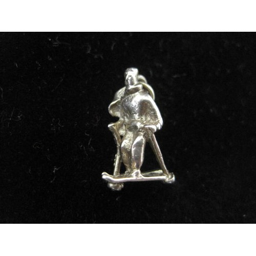 114 - 9 carat gold figural pendant of a skier, suspension loop indistinctly stamped 375, 1.6cm, 2g; a Brit... 