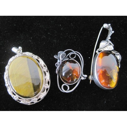 117 - A tiger's eye crystal oval pendant in a setting modelled with leaves and berries, with marks for Bir... 