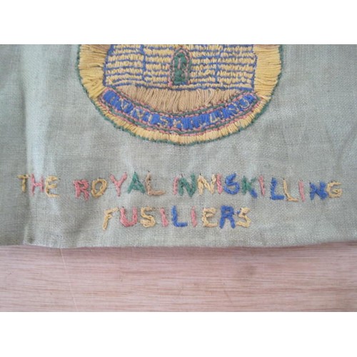 144 - An embroidered panel featuring the badge of the Royal Inniskilling Fusiliers