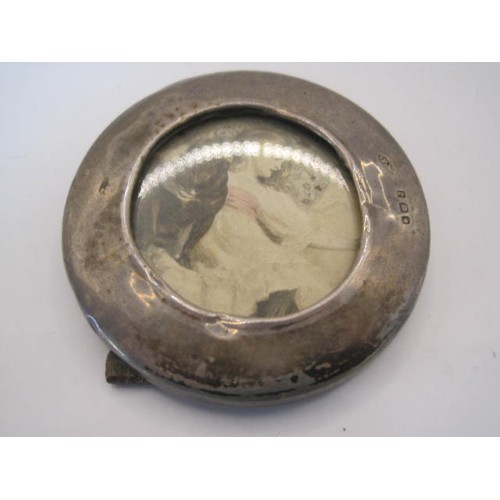 23 - Small circular silver photograph frame, overall diameter 6cm, visible aperture 3.7cm, wooden back an... 