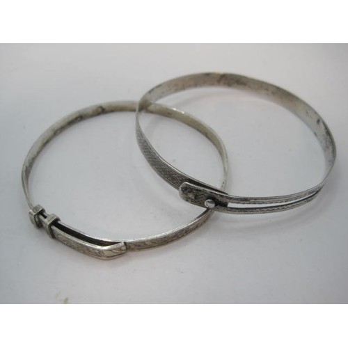 94 - Two silver bangles - the first with engine turning, marks for London, 1946, R G Springall & Co Ltd, ... 