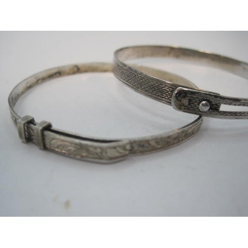 94 - Two silver bangles - the first with engine turning, marks for London, 1946, R G Springall & Co Ltd, ... 